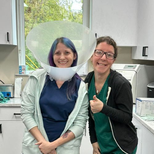 Female Veterinary staff wearing a cone next to another staff member