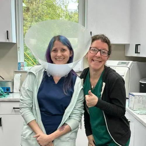 Female Veterinary staff wearing a cone next to another staff member